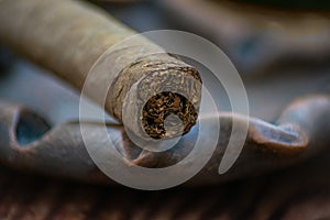 Closeup photo of a cigar on a clay ashtray