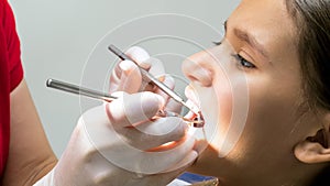 Closeup photo of dentist inspecting kids teeth with special instuments