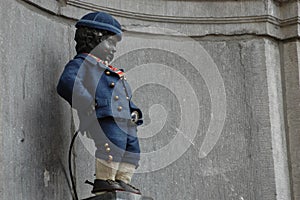 Closeup photo with dressed Manneken Pis, a little statue of boy urinating in Brussels, Belgium - landmark