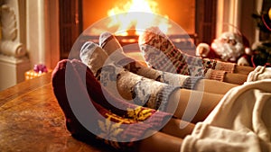 Closeup photo of family feet in woolen socks lying next to fireplace