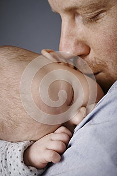 Closeup photo of father kissing newborn baby