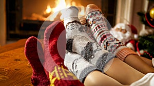 Closeup photo of female feet in warm woolen socks warming by the fireside at house