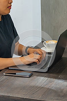 Closeup photo of female hands typing laptop keyboard at coffeeshop