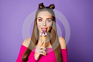Closeup photo of funny childish lady two pretty buns stick tongue out mouth lick vanilla ice cream wear pink off