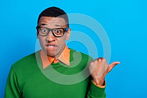 Closeup photo of funny guy bite lips wear green pullover with shirt smart nerd finger directing mockup nervous isolated