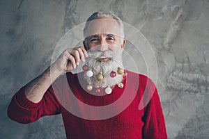 Closeup photo of funny old santa claus man colorful toy balls in long beard x-mas decorations after salon wear red