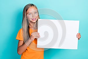 Closeup photo of little cute positive learner girl hold paper white billboard information about next test preparation