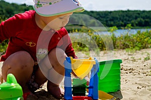 Closeup photo of a little girl. A child plays with the sand on the beach.