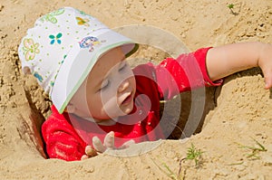 Closeup photo of a little girl. A child plays with the sand on the beach.