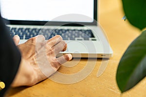 Closeup photo of Man`s hands typing on laptop keyboard