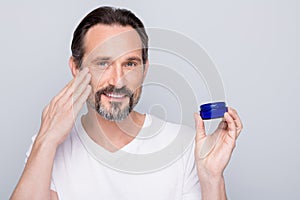 Closeup photo of mature macho guy holding new night cream applying cheek skin metrosexual want get rid of wrinkles wear photo