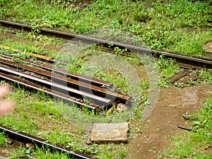 Closeup photo of old rusty and broken railroad rails lying on the ground