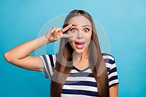 Closeup photo of pretty beautiful lady long hairdo showing two fingers v-sign near eye good mood open mouth excited wear