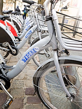 Closeup photo of rental bikes parked on the old narrow street of european town