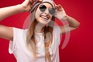 closeup photo shot of beautiful positive smiling young dark blonde woman wearing casual clothes and stylish sunglasses