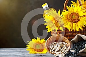 Closeup photo of sunflowers and sunflower oil with seeds on on a wooden table. Bio and organic concept of the product.