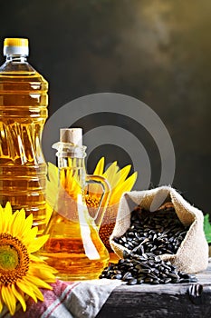 Closeup photo of sunflowers and sunflower oil with seeds on on a wooden table. Bio and organic concept of the product.