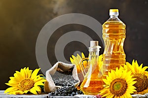 Closeup photo of sunflowers and sunflower oil with seeds on on a wooden table. Bio and organic concept of the product.