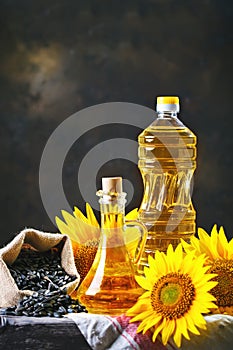 Closeup photo of sunflowers and sunflower oil with seeds on on a wooden table. Bio and organic concept of the product.