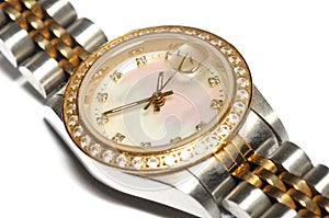 A silver ladies watch with a round watch face and diamonds on the rim