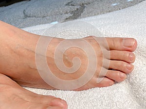 Closeup  photo of woman feet and toes on white towel