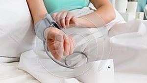 Closeup photo of woman putting on sleeve of digital blood pressure manometer