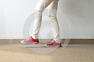 Closeup Photo of From Woman Wearing Red Sneakers On The Concrete Floor Background