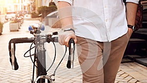 Closeup photo of young man with bicycle commuting to work