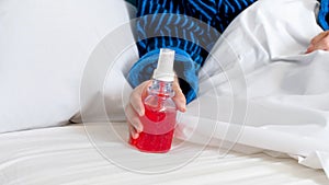 Closeup photo of young sick woman holding thoat spray in hand