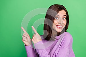 Closeup photo of young stunning cute girl toothy smile direct fingers empty space isolated on green color background