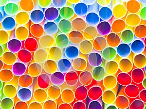 Closeup photograph of the ends of numerous multi colored neon bendy flexible straws including red, green, yellow, orange, blue,