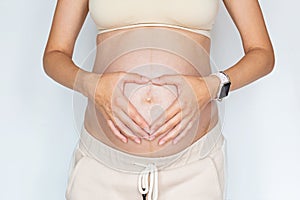 Closeup photography of young Woman touching hands her naked big belly Isolated on white background with copy space. Skin