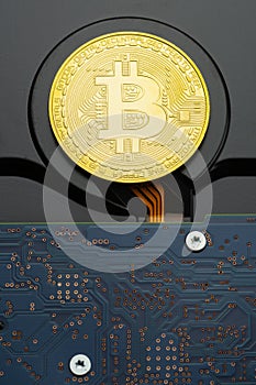 Closeup of physical Bitcoin criptocurrency coin on hard disk drive