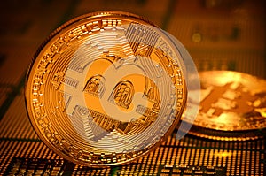 Closeup of physical bitcoin over computer cpu processors aligned.