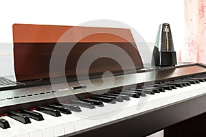 Closeup piano keyboard with metronome background.