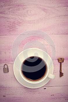 Closeup picture of cup of coffee with lock and key