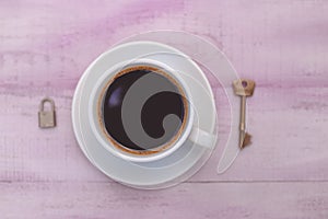 Closeup picture of cup of coffee with lock and key