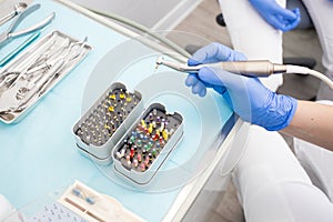 Closeup picture of dental instruments: drill and needle for root canal treatment and pulpitis in hand at the dentist