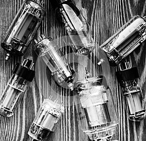 Closeup picture with different generations of electronic vacuum tubes in black and white.