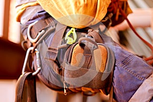 Closeup picture of male rope access worker wearing fall arrest full safety harness setting on a chair