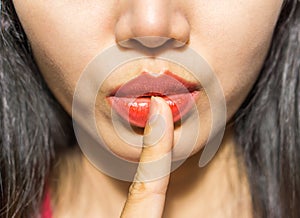 Closeup picture of woman making a hush gesture