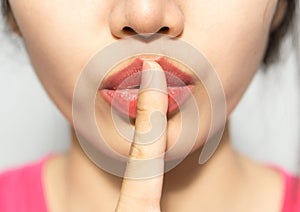 Closeup picture of woman making a hush gesture
