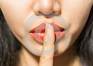 A Closeup picture of woman making a hush gesture