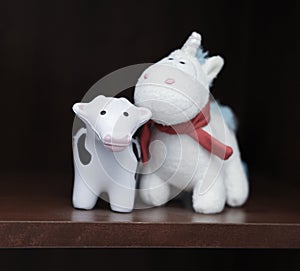 Closeup of a piggie and a cow toys on a shelf photo