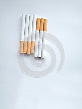 Closeup of a pile of cigarettes over white background. The tobacco can cause numerous damages to the organism