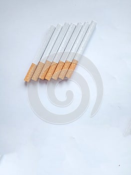 Closeup of a pile of cigarettes over white background. The tobacco can cause numerous damages to the organism