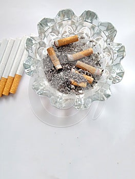 Closeup of a pile of cigarettes over white background. The tobacco can cause numerous damages to the organism