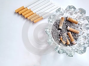 Closeup of a pile of cigarettes over white background. The tobacco can cause numerous damages to the organism