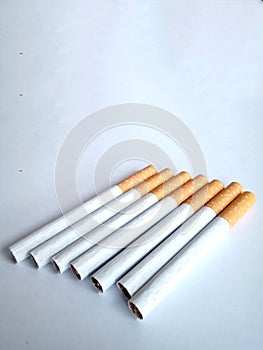 Closeup of a pile of cigarettes over white background. The tobacco can cause numerous damages to the organism