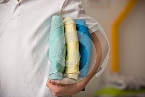 Closeup of a pile of colorful jeans in child`s hand. consumerism concept. Shopping